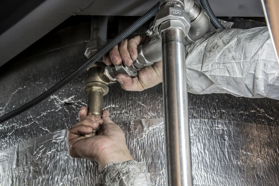 Reflective foil insulation and plumbing routed beneath a home in the crawl space